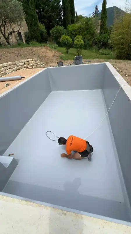 Pose de membrane PVC armé gris clair dans une piscine en rénovation