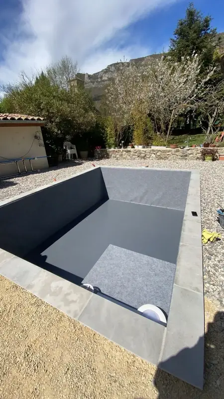 Piscine avec membrane PVC armé gris foncé et finitions contemporaines