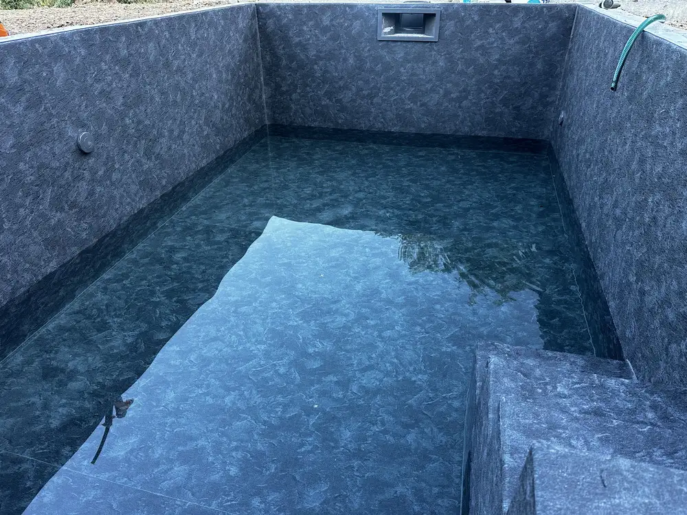 Piscine en cours de remplissage avec membrane PVC armé granit anthracite