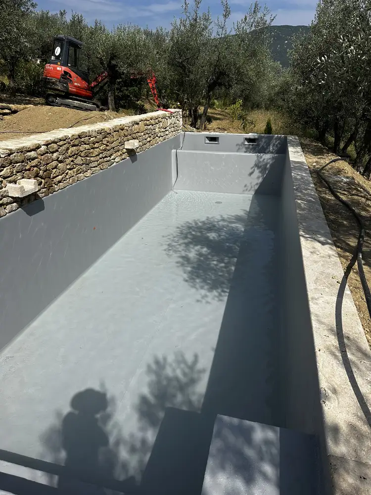 Piscine avec membrane PVC armé gris entourée d'oliviers en Provence